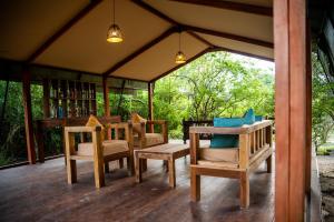 - un kiosque avec des chaises et des tables sur une terrasse couverte dans l'établissement Wild Trails Yala by Suri, à Yala