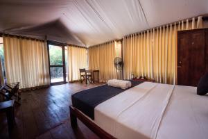 a bedroom with a large bed and a table at Wild Trails Yala by Suri in Yala