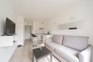 a white living room with a couch and a table at Studio Cosy 2 min Gare - 10 min in Bussy-Saint-Georges