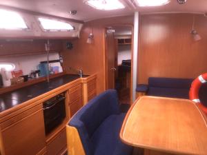 eine Küche mit einem Holztisch und blauen Stühlen in der Unterkunft BENNO » Segelyacht am Ijsselmeer mit 3 Kabinen in Lemmer