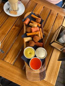 una bandeja de comida con aperitivos y salsas de inmersión en una mesa en BENNO » Segelyacht am Ijsselmeer mit 3 Kabinen, en Lemmer