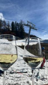 two glasses of white wine sitting next to each other at Chalet Alpin suisse in Veysonnaz