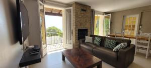 a living room with a couch and a fireplace at COSY COTTAGE with private pool in La Turbie
