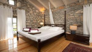 a bedroom with a bed in a stone wall at Villa Rosemary in Bajčići