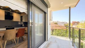 a kitchen with a sliding glass door leading to a balcony at PALM BEACH APARTMENT in Kuşadası