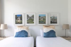 2 camas en una habitación blanca con cuadros en la pared en Charming Madrid Pacífico, en Madrid