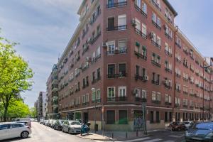 duży budynek z czerwonej cegły przy ulicy miejskiej w obiekcie Charming Madrid Pacífico w Madrycie