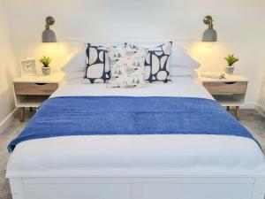 a bedroom with a blue and white bed with pillows at Keyland Cottage in Johnshaven
