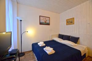 een slaapkamer met een blauw bed en handdoeken bij Nella Apartment in Rovinj