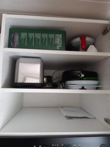 une étagère avec de la vaisselle et une boîte dans le réfrigérateur dans l'établissement Maison de ville Sélestat centre, à Sélestat