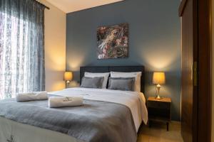 a bedroom with a large bed with two pillows on it at Anesis Suites in Volos