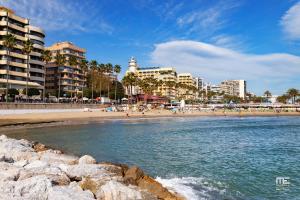 uma praia com um grupo de pessoas e edifícios em Jardines del Mar Beach - WiFi 539 em Marbella