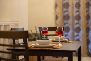 twee glazen rode wijn zittend op een tafel bij Anesis Suites in Volos