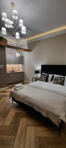 a bedroom with a large bed and a kitchen at Apartament Salsa in Krakow