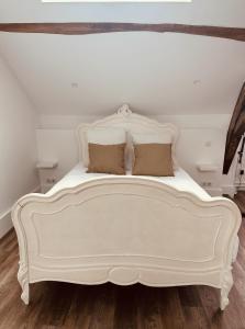 a white bed with two pillows on top of it at Studio 3 du SPA Célinie in Warcq