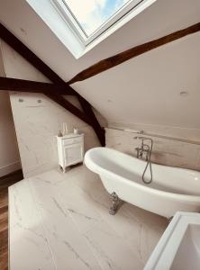 a bathroom with a white tub and a skylight at Studio 3 du SPA Célinie in Warcq