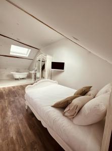 a bedroom with a large bed and a bath tub at Studio 3 du SPA Célinie in Warcq