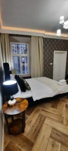 a bedroom with a large bed and a table at Apartament Salsa in Krakow