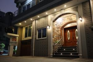 Hayyat Luxury Suites في لاهور: منزل عليه باب خشبي وسلالم