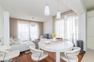 uma sala de estar branca com uma mesa e cadeiras brancas em Apartment Sunset, Zadar - Kožino em Kožino