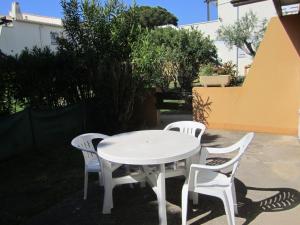 Biały stół i krzesła na patio w obiekcie 5097 Tennis Village 1603 w Cap d'Agde