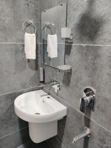 a bathroom with a white sink and a mirror at Hotel Tamanna - 50 Meter from Golden Temple in Amritsar +55 photos