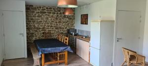 a kitchen with a small table and a kitchen with a brick wall at Chez perlette in Merle-Leignec