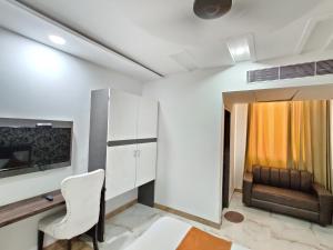 a room with a chair and a desk and a couch at Hotel Tamanna - 50 Meter from Golden Temple in Amritsar