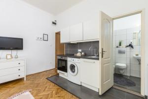 una cocina blanca con lavadora y secadora. en Real Apartments Wesselényi II., en Budapest