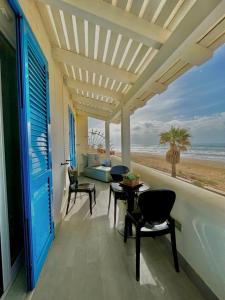 a balcony with a table and chairs and a view of the beach at HOLIDAY HOME AURORABIO- locazione turistica breve in Tre Fontane
