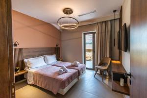 a hotel room with a bed and a desk and a window at Nestor Luxury Villas with Private Pools in Romanós