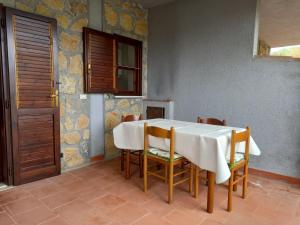 una sala da pranzo con tavolo e sedie bianchi di Villetta Elaion a Scario