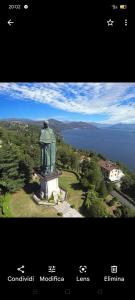 uma vista aérea de uma estátua em frente a uma massa de água em Sul Lungo lago da Tatiana B&B em Dagnente