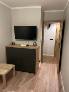 Przy Błoniach في شتتين: غرفة معيشة مع تلفزيون بشاشة مسطحة على الحائط