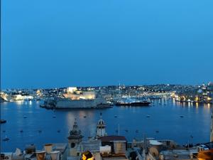 vista su una città con porto di notte di Ripple 23 Savynomad Harbour Residences a La Valletta