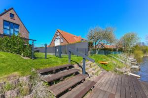 een houten bank die op een waterlichaam zit bij Ferienhaus HarleSand in Carolinensiel