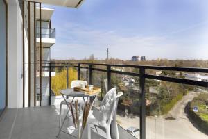 a balcony with a table and two white chairs at Elite Apartments Majewskich in Gdańsk