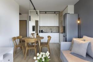 a kitchen and living room with a table and a couch at Elite Apartments Majewskich in Gdańsk