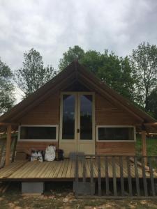 a small cabin with a wooden deck and windows at Canadienne in Le Fay +17 photos