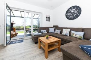 een woonkamer met een bank en een tafel bij Ferienhaus HarleSand in Carolinensiel