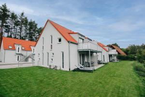 a row of white buildings with an orange roof at BrombachSeeZeit in Pleinfeld