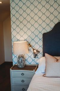 a lamp on a night stand next to a bed at Finch's Arms in Oakham
