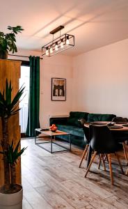 uma sala de estar com um sofá verde e uma mesa em Lavender Hill Apartment em Gdansk