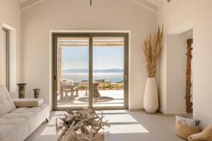 a living room with a couch and a view of the ocean at Spathes Suites Kefalonia - Luxury Suites in Ratzaklíon