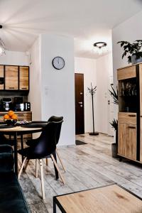 uma sala de estar com uma mesa e um relógio na parede em Lavender Hill Apartment em Gdansk