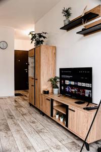 uma sala de estar com televisão e piso em madeira em Lavender Hill Apartment em Gdansk