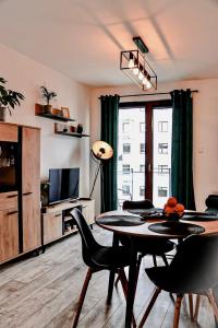 uma sala de estar com uma mesa e cadeiras e uma televisão em Lavender Hill Apartment em Gdansk