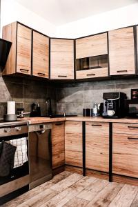 uma cozinha com armários de madeira e uma bancada em Lavender Hill Apartment em Gdansk