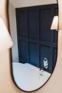 a mirror reflection of a blue door with a faucet at Finch's Arms in Oakham