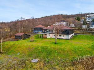 ein großes Haus auf einem grünen Rasen in der Unterkunft Hus med egen strandlinje in Tromsø
